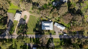 Vue aérienne d’une propriété comprenant un grand bâtiment, une allée et de la végétation environnante.
