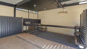 Un vaste espace intérieur doté d’un plafond en métal, d’un établi et d’étagères de rangement.