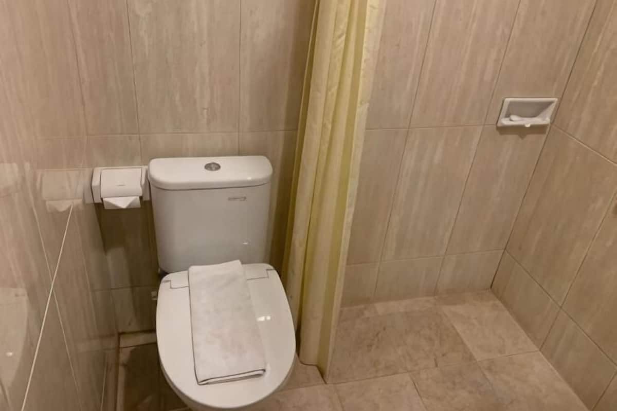 Kylpyhuone, jossa on wc, pyyhe ja wc-paperiteline.