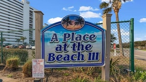 Un cartel para 'A Place at the Beach III' con un aviso de 'ZONA DE REMOLQUE'.