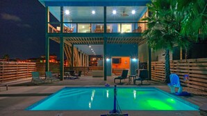 A two-story building with a pool in the foreground. - Bayfront Home w/ Pool, Game Room + Walk to Beach & Golf Cart Access Pelicans Perch by Avantstay (Port Aransas)