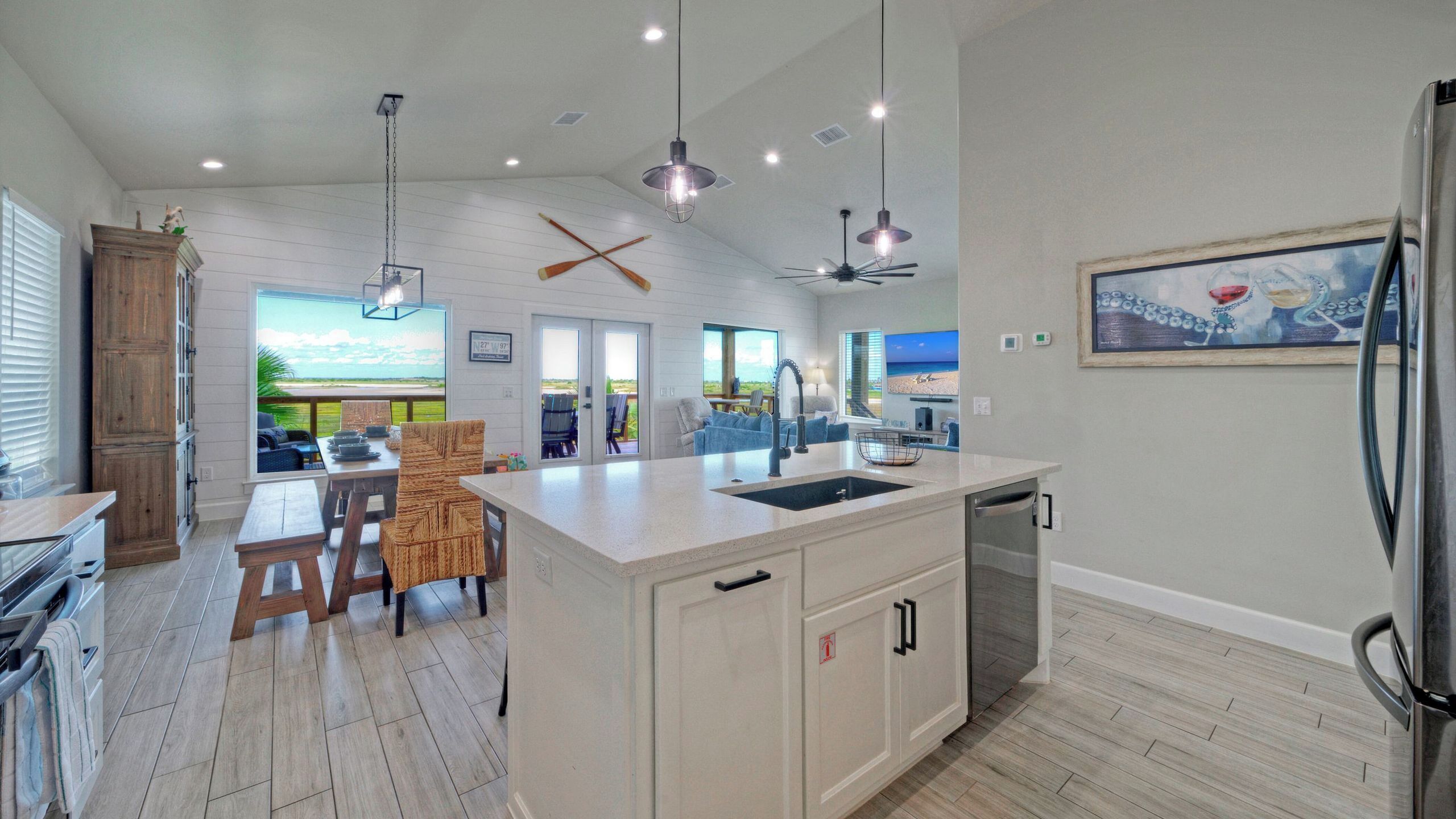 A spacious kitchen with a large island, wooden cabinets, and a view of the outdoors.