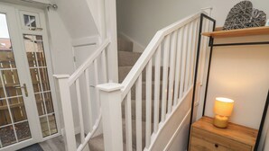 A staircase with white railings leading to an upper floor. - Nobles Nook (Seahouses)