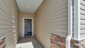 A narrow hallway with beige siding and a stone accent wall. - 25 Mi to Cedar Breaks: Unit w/ Furnished Patio! (Cedar City)
