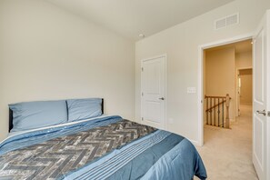 A bedroom with a bed, a door, and a hallway leading to another room. - Room to Work + Relax! Spacious Unit Near Charlotte (Stallings)