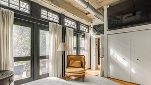 A room with large windows, a chair, a wardrobe, and a lamp. - Extended Stay: Walk to UIC Campus & Train! (Chicago)