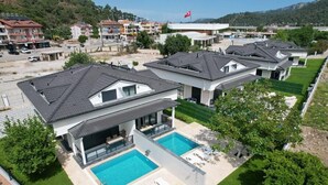 A modern residential complex with multiple houses, a swimming pool, and a flag.