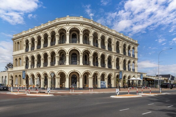 A multi-story building with a classical architectural style, featuring arched windows and balconies.