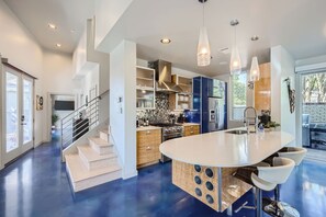 A modern kitchen with a central island, stainless steel appliances, and pendant lighting. - 5BR w/Guest House, Hot Tub, Dome, 3-minutes to Downtown Austin!! (Austin)