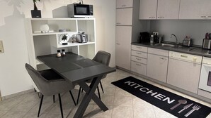 Eine moderne Küche mit Essbereich, ausgestattet mit Mikrowelle, Toaster und Kaffeemaschine.