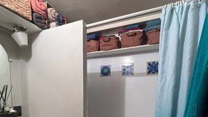 A bathroom with a shower, a sink, a mirror, and a towel rack. - Cozy studio (Paris)
