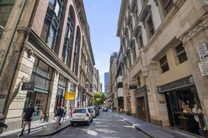 A street view with historic buildings, a clear sky, and pedestrians. - Classic 1-bed City Stay Near Eateries and Laneways (Melbourne)