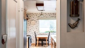 A kitchen with a wooden table and chairs, a window, and a wall-mounted clock. - Cozy, Low-Key, Perfect for Short & Extended Visits (Salt Lake City)