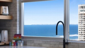 Eine Küche mit Fenster zum Meer und einem hohen Gebäude.