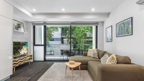 Un salon moderne avec un canapé, une petite table en bois et une bibliothèque.