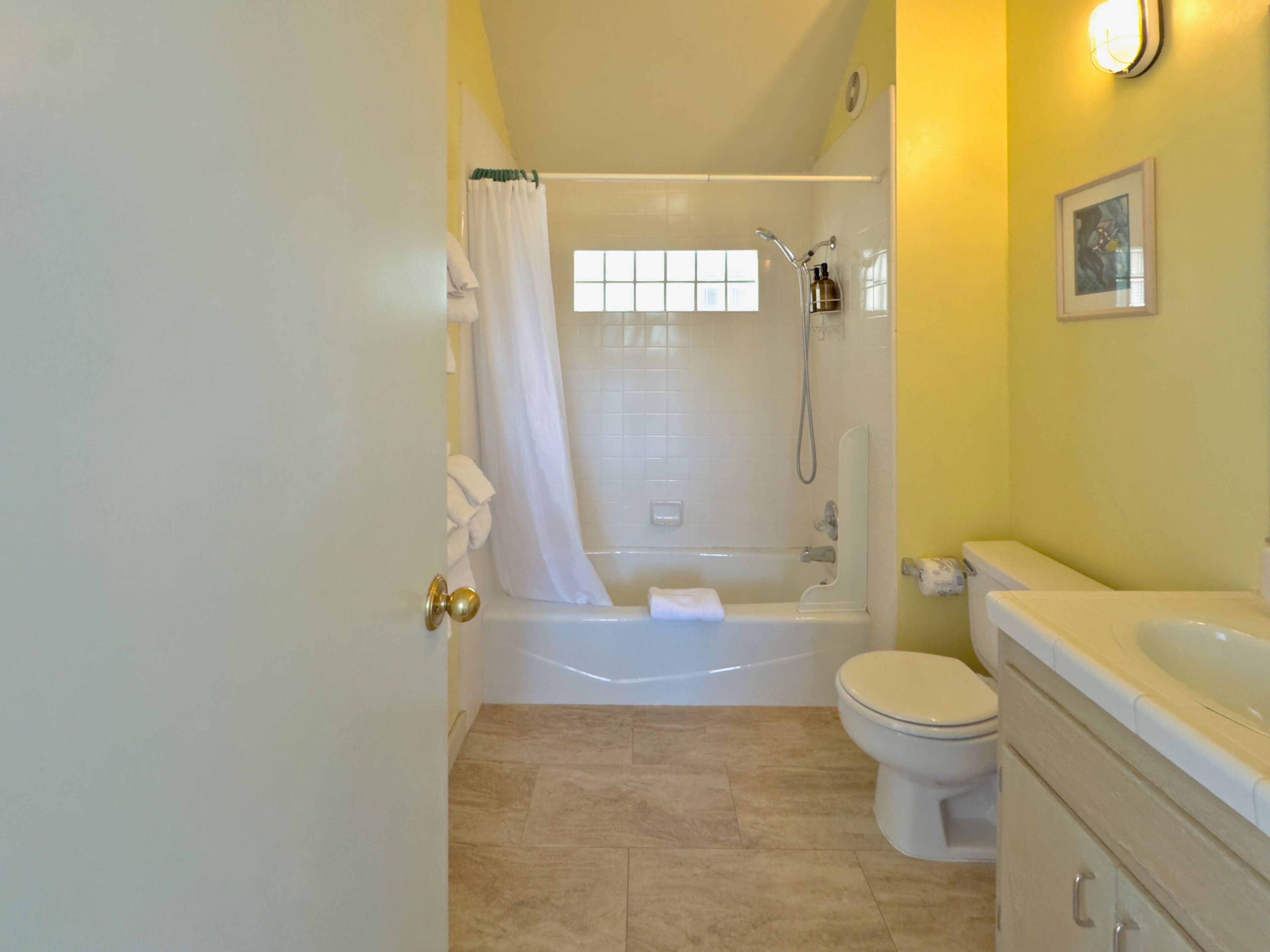 A bathroom with a bathtub, toilet, and sink.