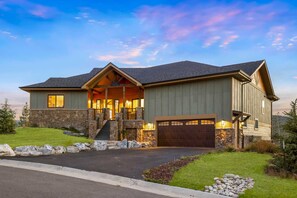 A two-story house with a stone foundation, a front porch, and a garage. - New built, stunning home with Hot Tub, 5/4, near Granby Ranch - sleeps 16 (Granby)