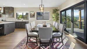 A modern kitchen with a dining area, large windows, and a view of the outdoors. - New built, stunning home with Hot Tub, 5/4, near Granby Ranch - sleeps 16 (Granby)