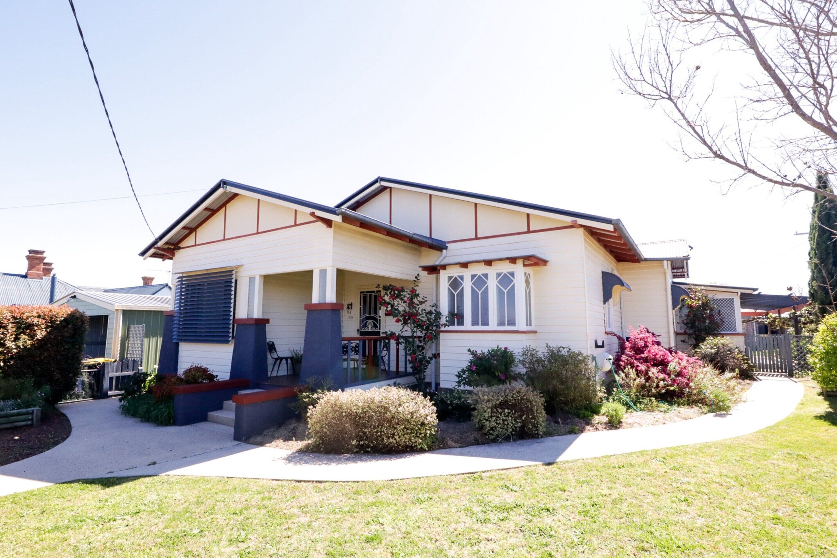 A two-story house with a front porch, a garage, and a well-maintained lawn.