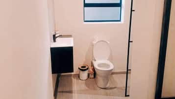 Een douche, handdoeken, zeep, toiletpapier