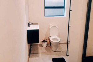 Een douche, handdoeken, zeep, toiletpapier