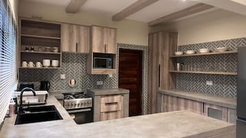 Una cucina moderna con mobili in legno, un forno a microonde integrato e un piano cottura in acciaio inossidabile.