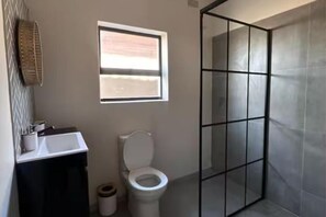 Een douche, handdoeken, zeep, toiletpapier