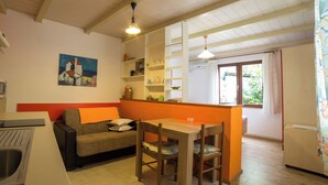 Une cuisine de taille réduite avec un coin repas, un canapé et un tableau accroché au mur.