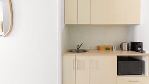 A small kitchenette with a sink, a coffee maker, and a microwave.