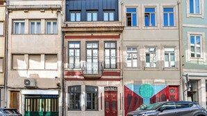 A row of multi-story buildings with distinct architectural styles, including a red door and a balcony. - Studio in the center of Porto for tourism or remote work (Porto)