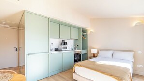 A compact bedroom with a bed, a small kitchenette, and a bathroom. - Studio in the center of Porto for tourism or remote work (Porto)