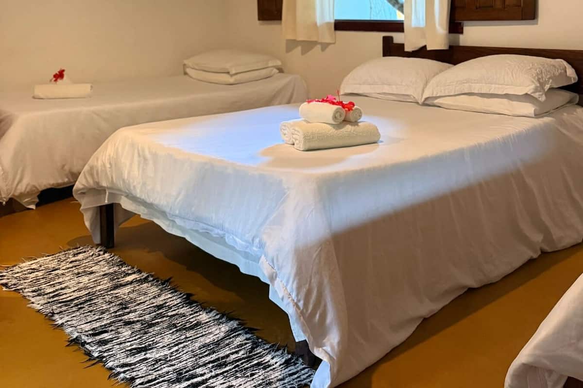 A hotel room with two beds, a black and white rug, and white bedding.