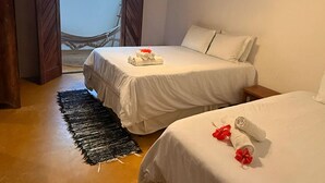 A hotel room with two beds, a black woven rug, and a hammock in the background. - Corais Do Sul (Porto Seguro)