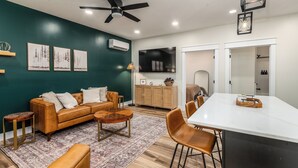 A modern living room with a sofa, coffee table, and dining area. - Stylish 1BR Downtown • Near Garden of the Gods (Harrisburg)