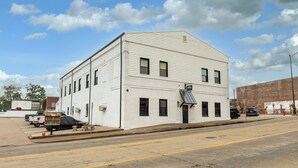 A white two-story building with a flat roof and a small awning. - Stylish 1BR Downtown • Near Garden of the Gods (Harrisburg)