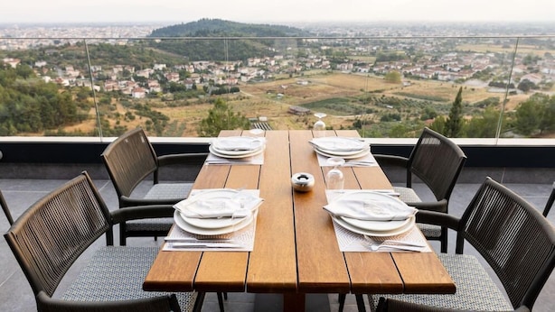 A table set for four with a view of a town and hills in the background. - Ananti Resort & Spa (Trikala)