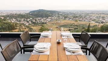 A table set for four with a view of a town and hills in the background.