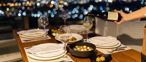 A table set for dining with plates, glasses, and a bottle being poured.