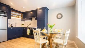 A modern kitchen with dark blue cabinets, a wooden floor, and a round table with chairs. - Warrenpoint Centre, Town House Co. Down
Perfect to explore Carlingford Lough (Warrenpoint)