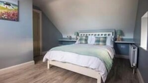 A bedroom with a bed, bedside tables, a radiator, and a painting on the wall. - Warrenpoint Centre, Town House Co. Down
Perfect to explore Carlingford Lough (Warrenpoint)