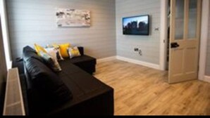 A modern living room with a black sofa, a coffee table, and a flat-screen TV mounted on the wall. - Warrenpoint Centre, Town House Co. Down
Perfect to explore Carlingford Lough (Warrenpoint)