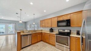 Una cucina moderna con mobili in legno, elettrodomestici in acciaio inossidabile e un'ampia finestra che garantisce luce naturale.
