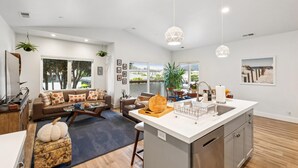 A spacious living room with a sofa, coffee table, and a view of the outdoors.