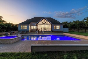 Ein Haus mit Swimmingpool, einer überdachten Terrasse und einem gepflegten Rasen.