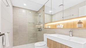 A modern bathroom with a shower, toilet, and vanity.