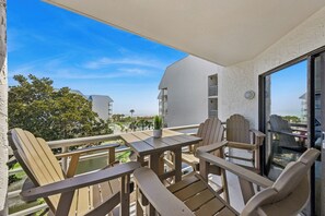 Ein Balkon mit Holzmöbeln, einem Blumentopf und Blick auf ein Feriengebiet.