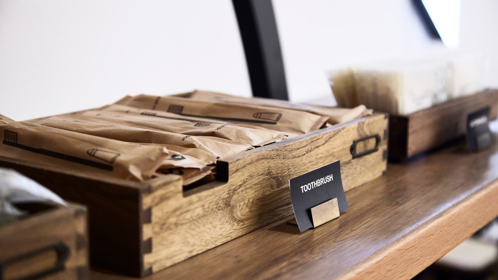 Una caja de madera con la etiqueta 'TOOTHBRUSH' sobre una superficie de madera.