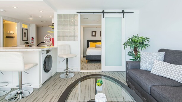Un appartement moderne comprenant une cuisine, un coin repas, un salon et une chambre.
