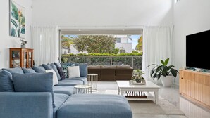 Un salon moderne avec un canapé bleu, une table basse et un téléviseur.