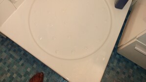Une salle de bain avec une baignoire, une douche et des toilettes. On trouve des produits de nettoyage sur le comptoir.